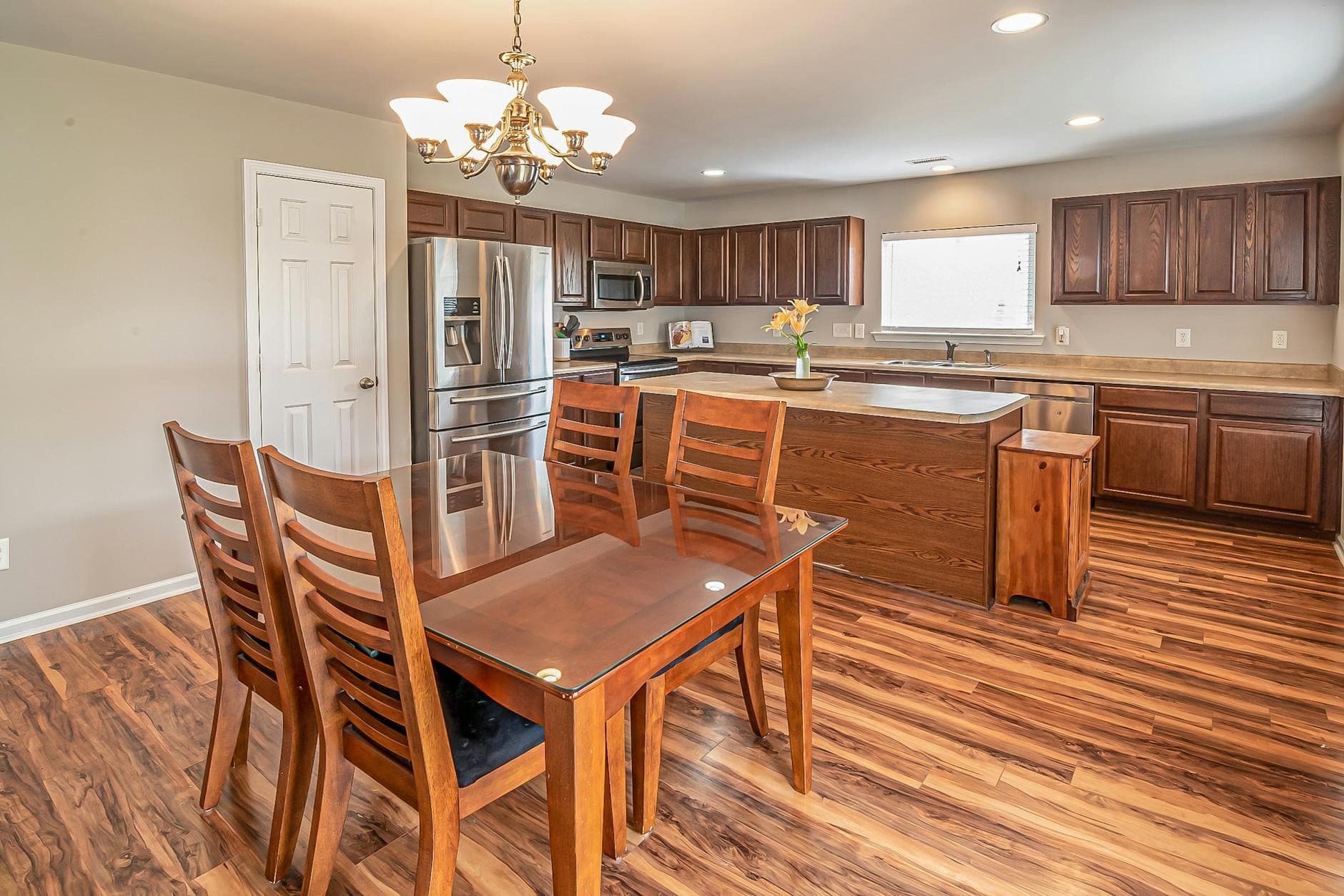 A modern kitchen and dining area featuring wooden floors and cabinetry, perfect for home design inspiration.
