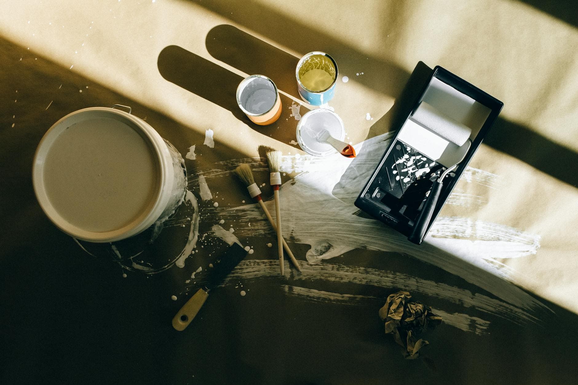 Creative top view of paint tools on canvas with shadows and splatters, perfect for artistic themes.